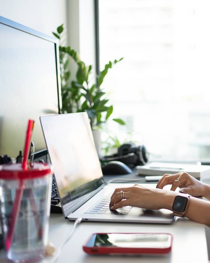 Women Using Laptop Near Window With Phone